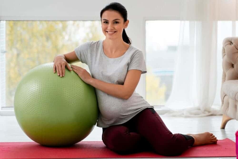 mujer embarazada haciendo ejercicio con pelota fitness